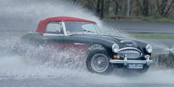 Austin-Healey 3000 Mk III mit rotem Verdeck im Regen